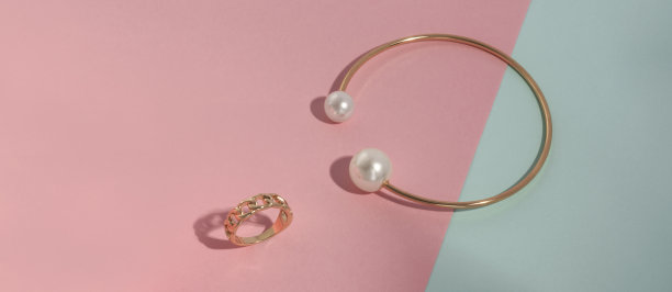 黄金与珍珠宝石手镯和链形状戒指在柔和的颜色的背景与复制空间图片下载