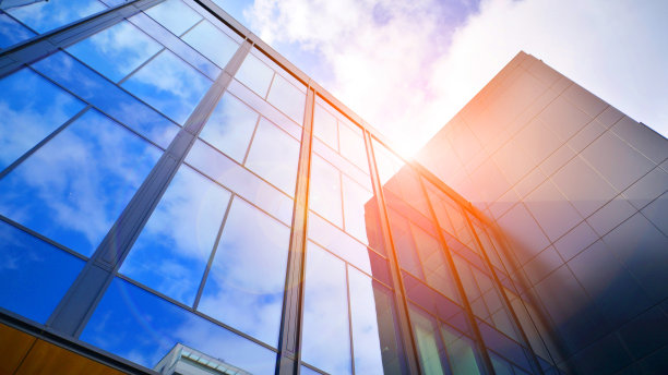 玻璃建筑与多云的蓝天背景。透视广角视图以钢浅蓝色为背景的玻璃。图片下载