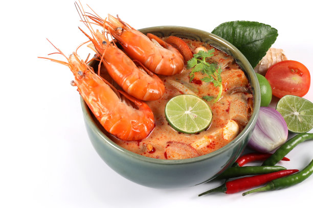 冬阴功宫辣。冬阴功在一个绿色的碗里，配料在白色的背景上，俯视图有拷贝空间。图片下载