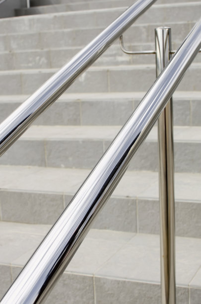 现代楼梯上的圆形金属栏杆，特写。图片下载