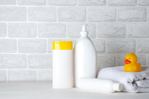 婴儿沐浴用品，毛巾，黄色橡皮鸭和洗发水瓶。儿童保育的概念。图片下载