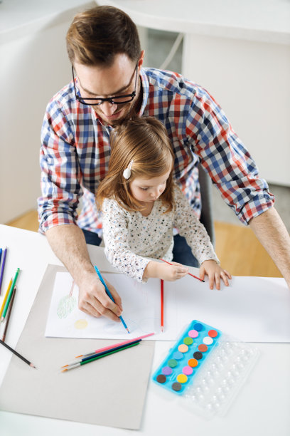 上图中，父亲和女儿在客厅里一边玩一边涂色图片下载