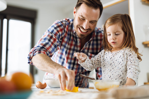 小女孩和她的父亲在厨房里烤面包图片下载