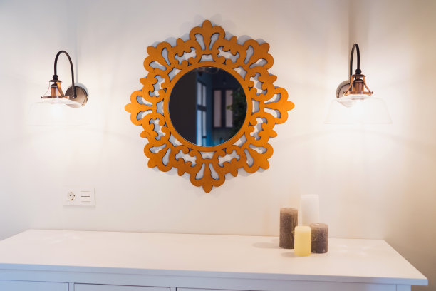 抽屉柜，上面有蜡烛，镜子和对称的灯。图片下载