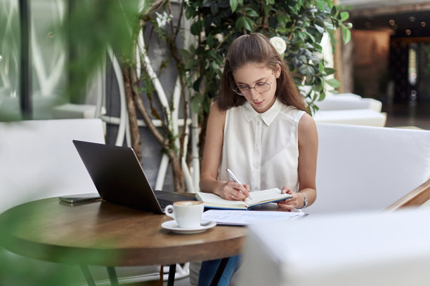 在笔记本上做笔记的网吧访客图片下载