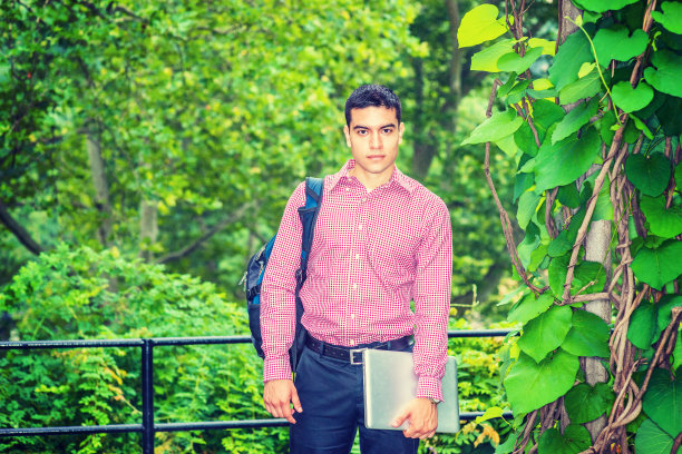 纽约，一个年轻人站在户外的绿叶旁图片下载