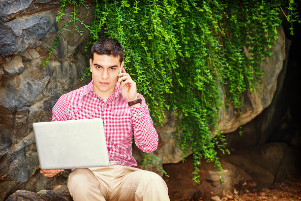 在纽约市户外用笔记本电脑工作的年轻人图片下载