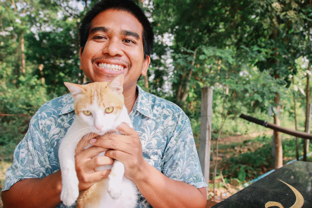 棕色皮肤的男人和他的猫玩图片下载