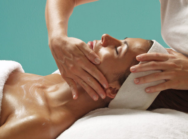 正在接受面部按摩治疗的妇女。图片下载