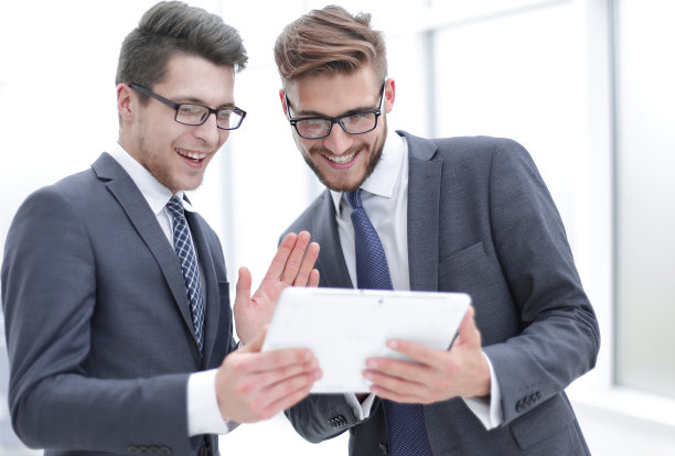 两个同事在讨论数字平板电脑上的信息图片下载