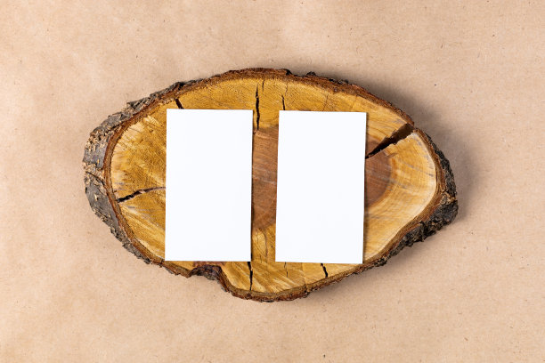 空的白色名片模拟在木砍树节米色背景。图片下载