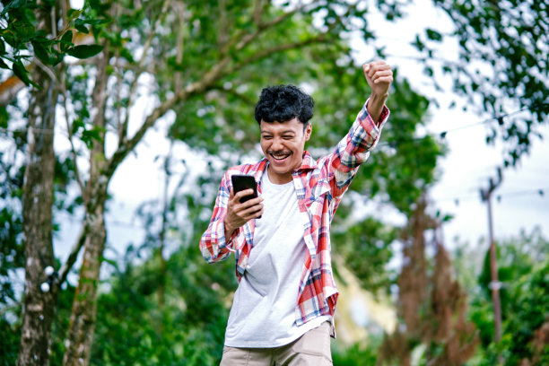 年轻人在户外玩手机游戏图片下载