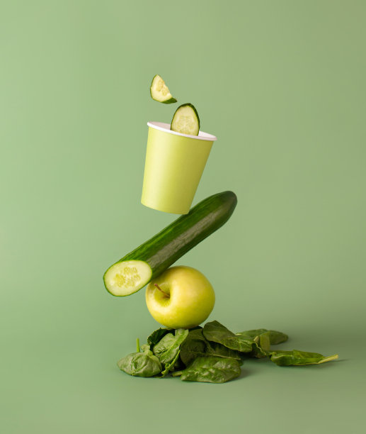 在桌子上平衡食物构图。菠菜，苹果，黄瓜汁，上面放一杯。鳄梨图片下载