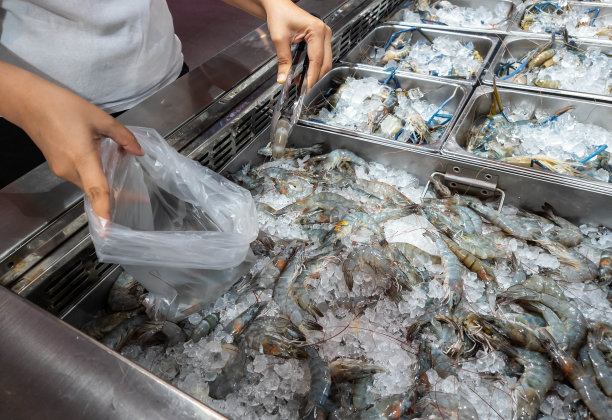 顾客在市场买虾。图片下载