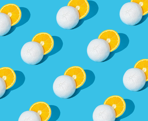 图案由白色画黄色葡萄柚切成一半在柔和的蓝色背景。最小的夏天的概念。图片下载