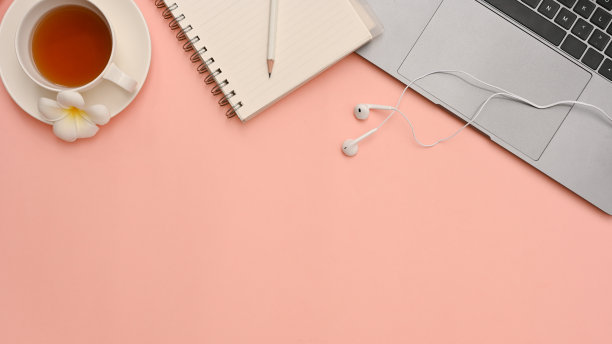 俯视图，女性工作空间与笔记本电脑和复制空间的粉红色背景。图片下载