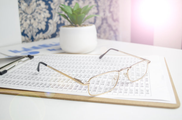 眼镜放在桌子上的财务图表上。图片下载