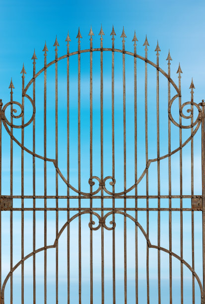 生锈的锻铁门与尖利的点在蓝天与云图片下载