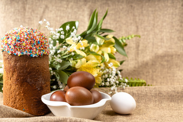 复活节蛋糕、彩绘蛋和春花的麻布背景组合，节日素材图片下载
