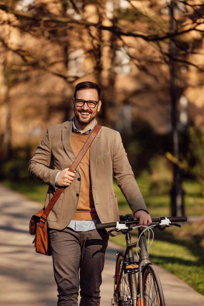 一个微笑的男人的肖像，从工作回来，推着自行车图片下载