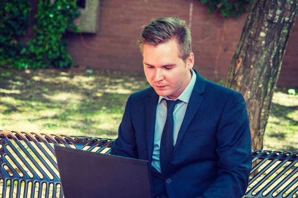 在纽约户外用笔记本电脑工作的年轻商人图片下载