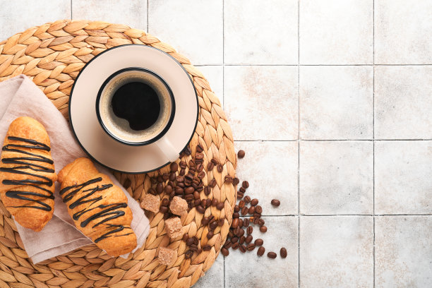 咖啡和羊角面包。有裂纹的旧瓷砖桌上放着浓缩咖啡和巧克力羊角面包。完美的羊角面包早餐。乡村风格。前视图。模拟。图片下载