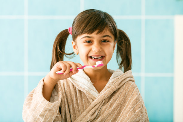 微笑的女孩在浴室里刷牙图片下载