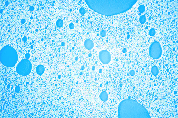 蓝色背景上白色洗发水泡沫的微距照片图片下载