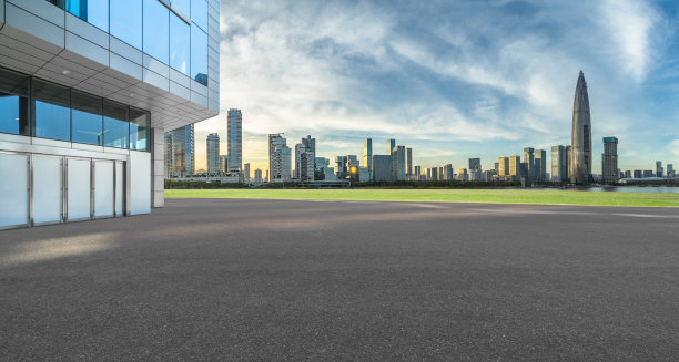 空荡荡的水泥地面和蓝天下的城市景观图片下载