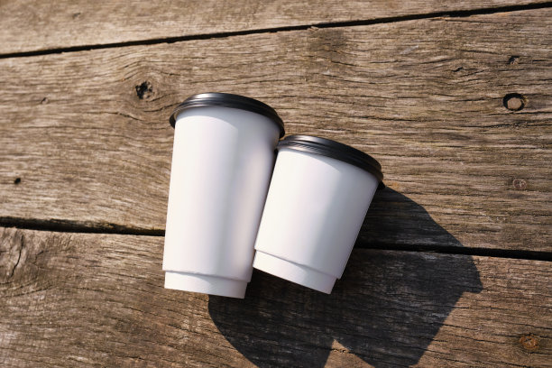 木制背景上的白色纸杯。是时候在城市里喝咖啡了。咖啡要走。享受这一刻，休息一下。一次性纸杯特写。美味的热饮。空白的文本，模型图片下载