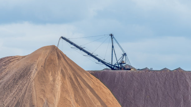 大型撒布机或撒布机。在垃圾填埋场上放置钾盐的大型倾倒机。提取钾盐。图片下载