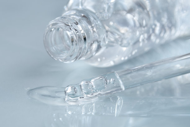 带液体透明质酸的移液管，蓝色背景上的开瓶。化妆品和保健概念特写图片下载