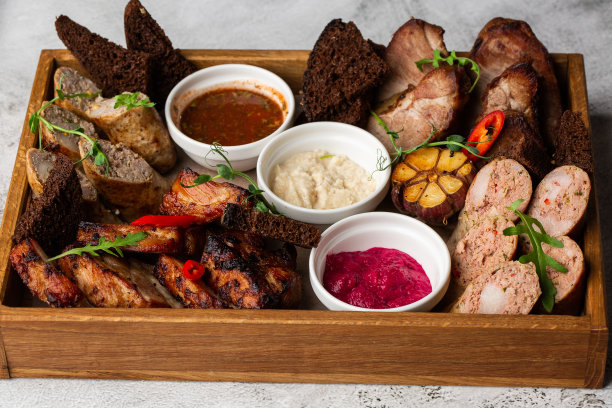 混合烤肉拼盘的特写照片。牛肉，猪肉，家禽，香肠，烤大蒜，辣椒，不同的酱汁图片下载