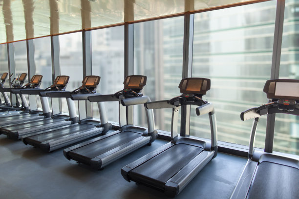 锻炼跑步机排列在工作室与城市的城市建筑的看法图片下载
