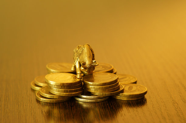黄金背景上有硬币的金属公牛。图片下载