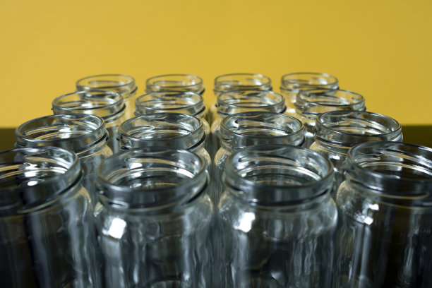 黄色背景上的空玻璃罐排成一排图片下载