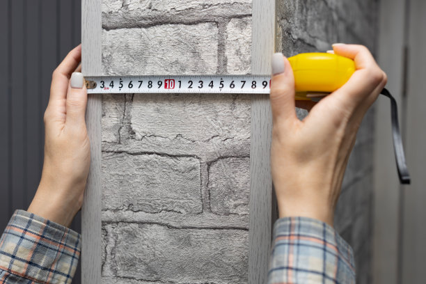一个女人用卷尺量墙上的壁架图片下载