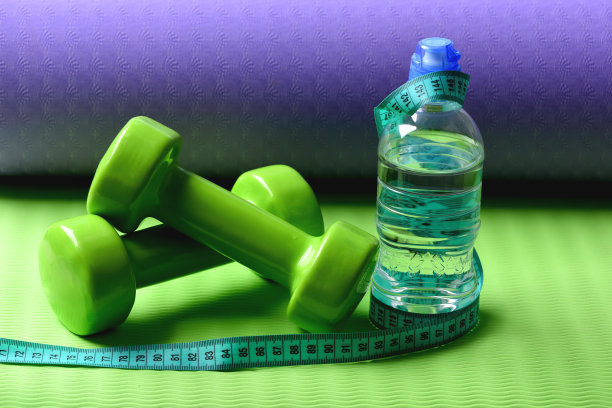 塑形健身器材。杠铃附近青色卷尺卷图片下载