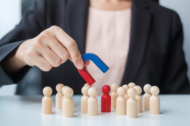 女商人手握磁铁，从人群中拉出男工木雕。商业，人力资源管理，招聘，团队合作，战略，有毒的人和领导理念图片下载