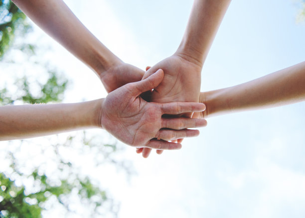 在世界环境日，人们志愿团队合作，手牵手，手叠，团结和团队合作的特写。图片下载