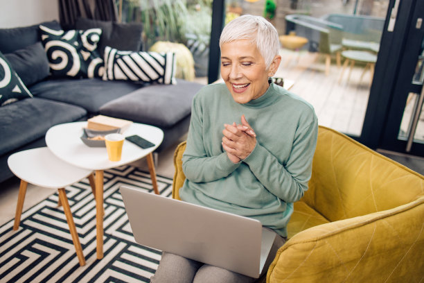 一位资深女商人在她的客厅里进行在线会议的肖像图片下载