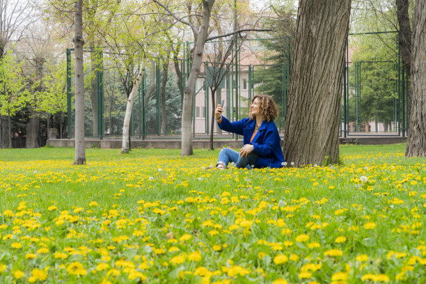 坐在繁花似锦的乡村的女人与春天的mevisimi图片下载