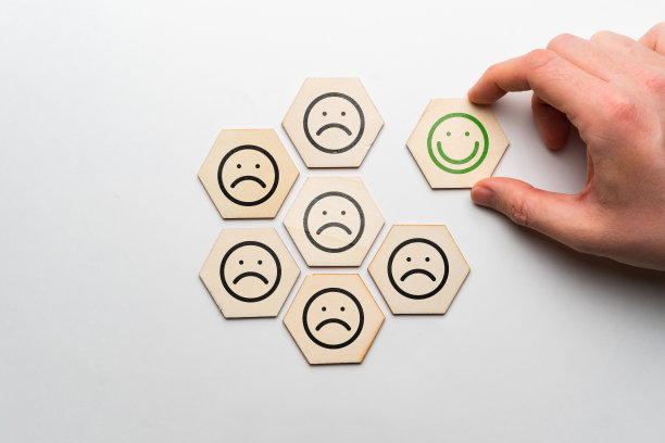 好心情的概念。木块上的表情符号悲伤和快乐。图片下载