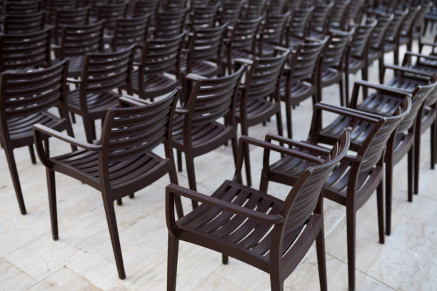 在一个开放的夏日广场上，许多塑料椅子排成一排图片下载