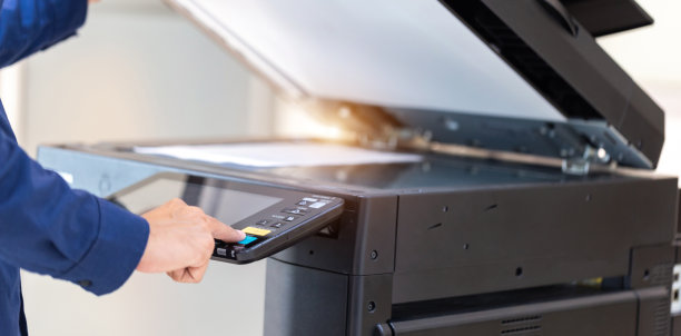 商人按下打印机面板上的按钮，复印机网络，在办公室工作复印的概念，打印机是办公人员扫描和复印纸张的工具设备。图片下载