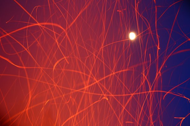 在明亮的月亮和星星的天空前散焦的火花痕迹图片下载