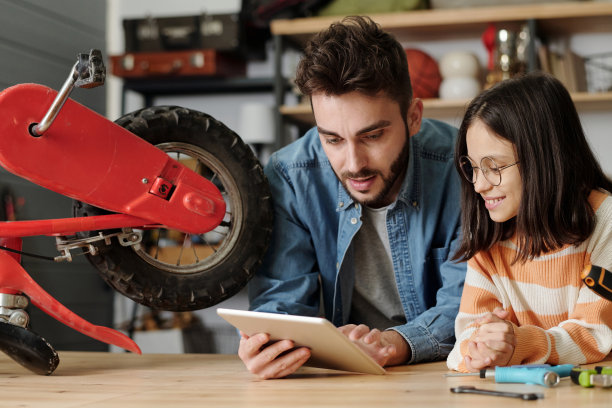 严肃的年轻男人用平板电脑展示他快乐的小女儿的在线页面图片下载