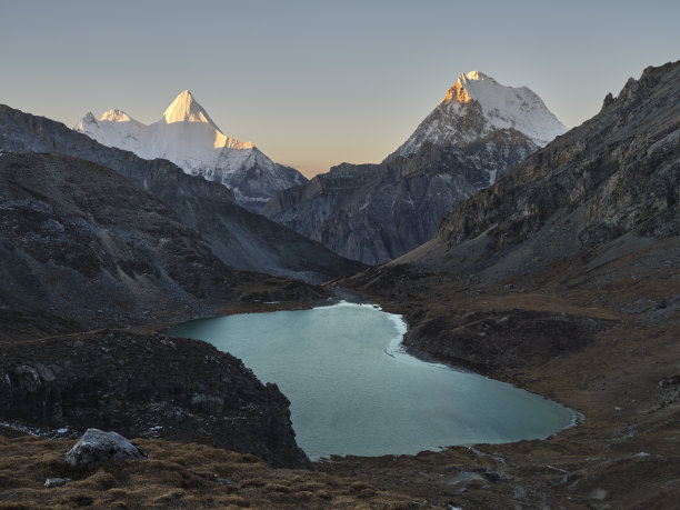 中国四川亚丁国家公园日出时的贾帕阳山、chanadorje和博永措湖图片下载