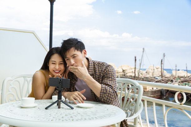 年轻夫妇在海景餐厅用手机视频聊天照片图片下载
