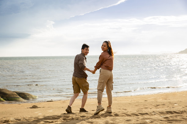 沙滩上散步的年轻情侣-照片图片下载